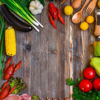 A vibrant arrangement of fresh vegetables and cooking utensils on a rustic wooden surface, perfect for culinary inspiration.