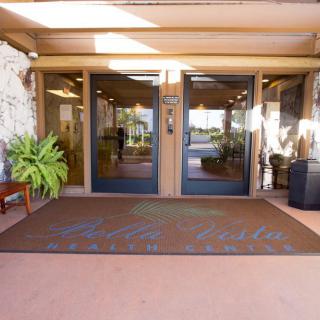 Front entrance with double doors and a welcome mat.