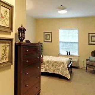 A cozy bedroom with classic wooden furniture and warm-colored walls.