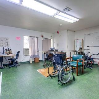 A rehabilitation room equipped with wheelchairs and physical therapy equipment.