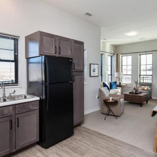 A modern apartment interior featuring an open space with a kitchen and living room.