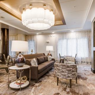 A luxurious and modern living room interior with elegant furniture and a grand chandelier.