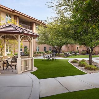 A peaceful courtyard with a gazebo and outdoor seating surrounded by well-maintained landscaping.