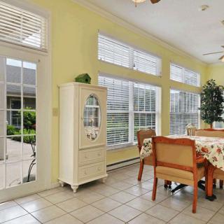 A bright dining room interior with large windows and wooden furniture.