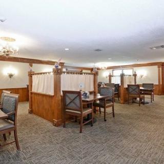 Interior view of a restaurant dining area with wooden paneling and carpeted flooring.
