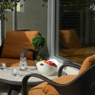 A cozy outdoor seating area featuring comfortable chairs and a stylish fruit bowl on the table.