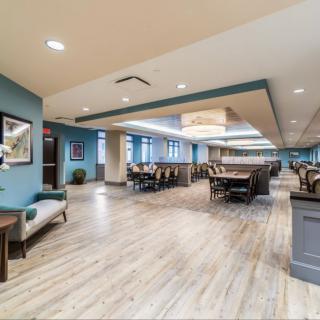 Spacious and modern dining area with elegant wooden flooring and ample seating.