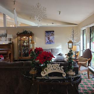 A cozy living room beautifully decorated for the Christmas season, featuring elegant furniture and festive poinsettias.