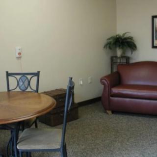 A small office waiting area with a sofa, table, and chairs.