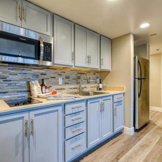 A modern kitchen interior with blue cabinets, stainless steel appliances, and a tiled backsplash.