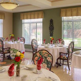 A well-decorated dining room with round tables and floral arrangements.
