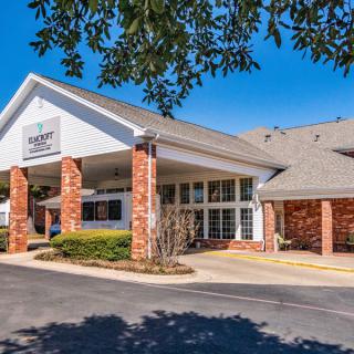 The entrance of a hotel building with brick columns and a peaked roof.