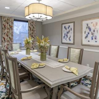 A beautifully decorated dining room with a large table, elegant chairs, and tasteful artwork on the walls.