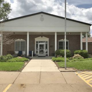 Front view of a public building with landscaped entrance.