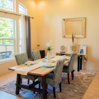 A beautifully arranged dining room filled with natural light, featuring a stylish table setting and modern furniture.