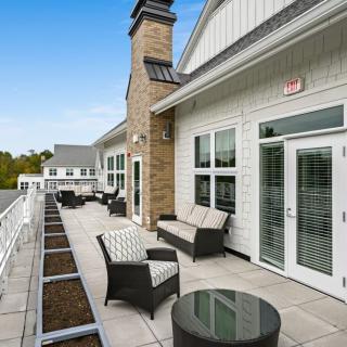 Modern outdoor patio with comfortable seating and large windows.
