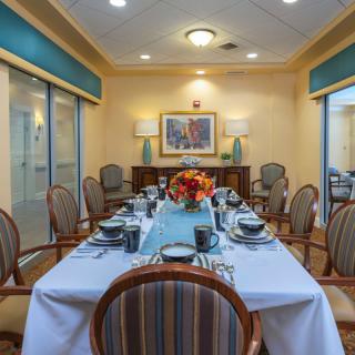 A beautifully set formal dining room with elegant table settings and decorative artwork.