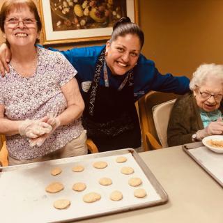 A group of people enjoying a baking session, making cookies together.