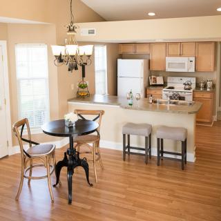 A modern open-concept kitchen and dining area with wood flooring and stylish furniture.