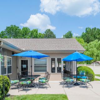 A sunny outdoor patio with blue umbrellas and seating.