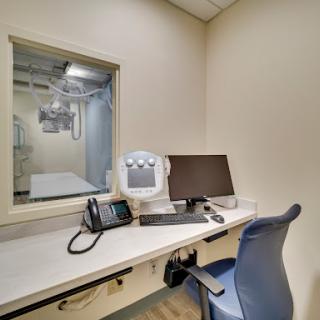 A view of a medical office workspace, featuring a desk with a computer and phone.
