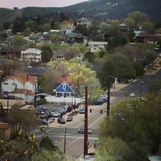 A view of a small town nestled among hills, showcasing residential buildings and streets.