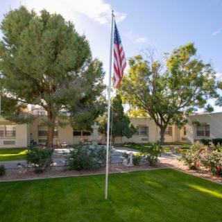 A well-maintained garden area with a flagpole and surrounding buildings.