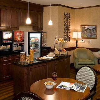 A cozy hotel breakfast area with a coffee station and comfortable seating.