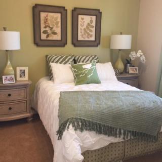 A cozy bedroom with green accents and elegant decor.