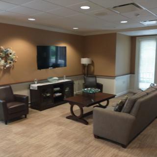 A modern living room with comfortable seating, a coffee table, and a mounted television.