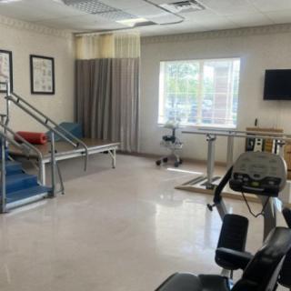 A rehabilitation room equipped with exercise machines and therapy tools.