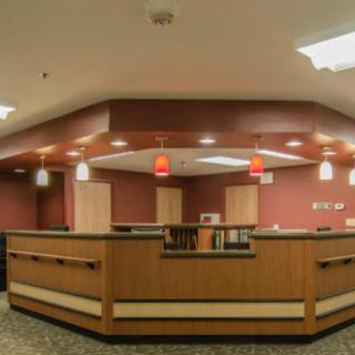 A modern reception desk in an office space with warm lighting.