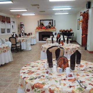 A beautifully arranged dining area with autumn-themed decorations and neatly set tables.