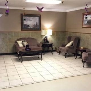 A cozy waiting room with elegant furniture and soft lighting.