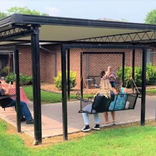 A cozy outdoor swing area where people enjoy their time together.