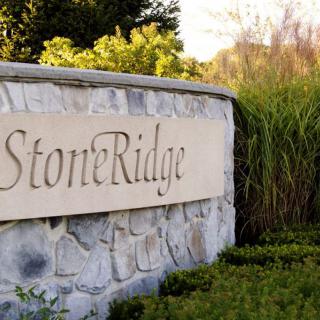 A stone wall with the inscription 'Stone Ridge' surrounded by greenery.