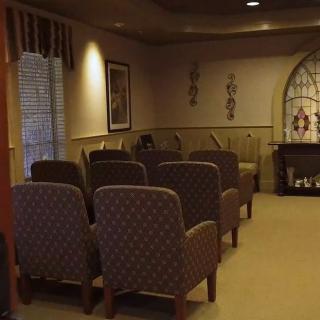 A small, cozy room with rows of chairs and decorative elements.