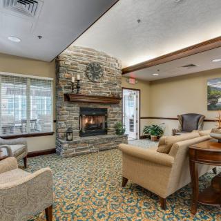A cozy living room with a stone fireplace and comfortable seating.