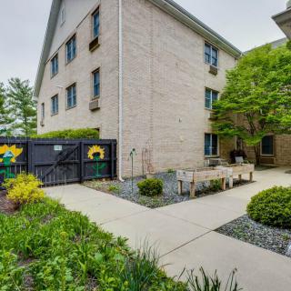 A peaceful outdoor garden area with benches adjacent to a multi-story building.
