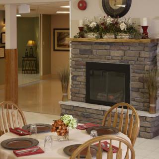 A cozy dining area featuring a stone fireplace and elegantly set tables.