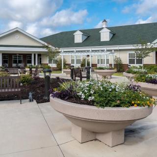 A landscaped patio area with planters and benches in front of a large building.