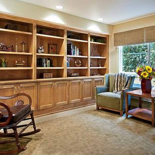 A cozy reading nook with built-in bookshelves, a comfortable armchair, and a bright window.