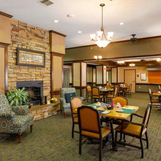 A cozy dining area with a fireplace, comfortable seating, and elegant chandeliers.