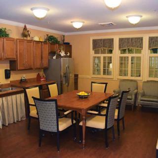 A cozy kitchen and dining area with a wooden table, chairs, and modern appliances.