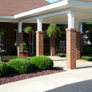 The entrance of a building with brick columns and well-maintained landscaping.