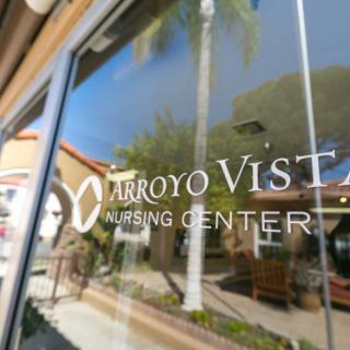 The front window of Arroyo Vista Nursing Center reflecting the surrounding environment.