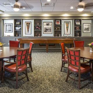 A well-decorated game room with tables and chairs, featuring framed artwork on the walls.