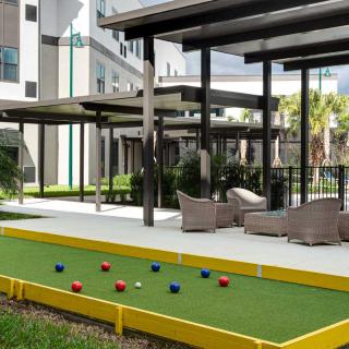 Outdoor seating area with a bocce court at an apartment complex.