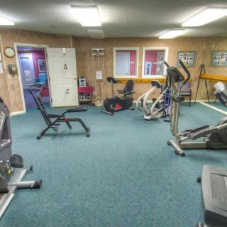 A home gym equipped with various exercise machines and a bench, providing a space for fitness and workouts.