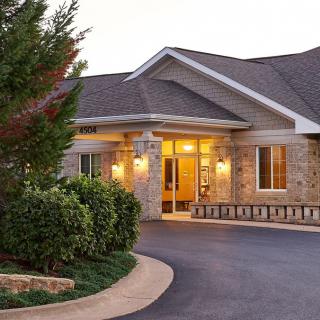 A welcoming building entrance with well-maintained landscaping and a clean driveway.
